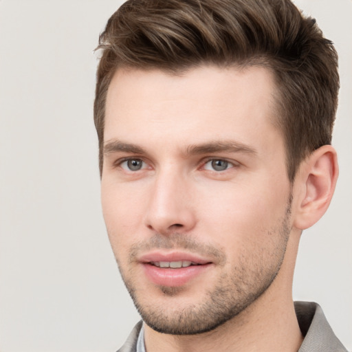 Joyful white young-adult male with short  brown hair and grey eyes