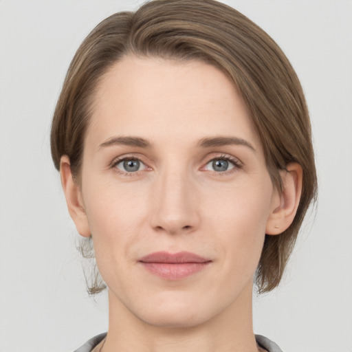 Joyful white young-adult female with medium  brown hair and grey eyes