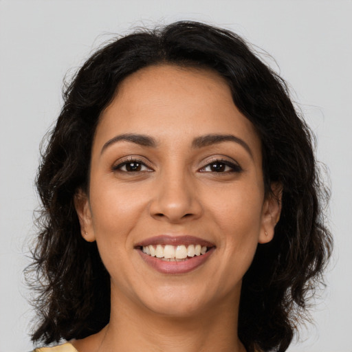 Joyful latino young-adult female with medium  brown hair and brown eyes