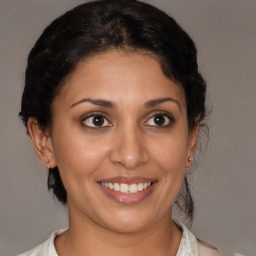 Joyful latino young-adult female with medium  brown hair and brown eyes