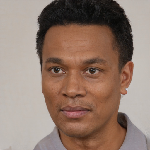 Joyful latino adult male with short  black hair and brown eyes