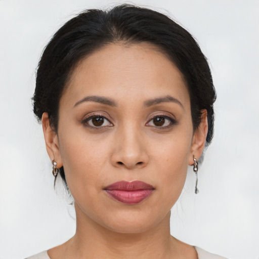 Joyful latino young-adult female with medium  brown hair and brown eyes