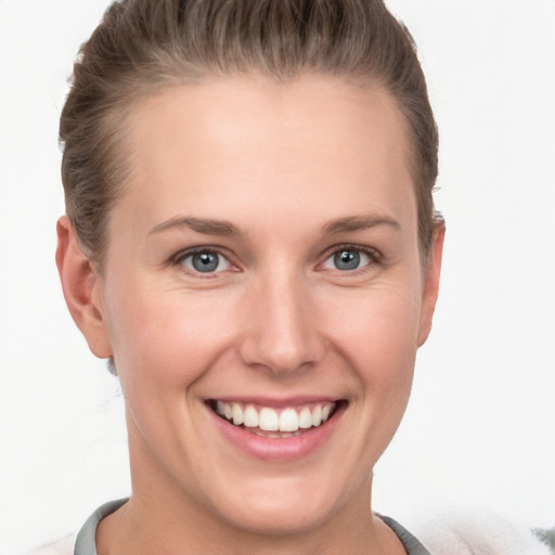 Joyful white young-adult female with short  brown hair and grey eyes