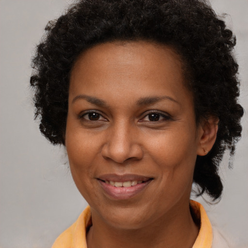 Joyful black adult female with short  brown hair and brown eyes