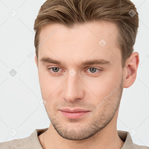 Joyful white young-adult male with short  brown hair and grey eyes