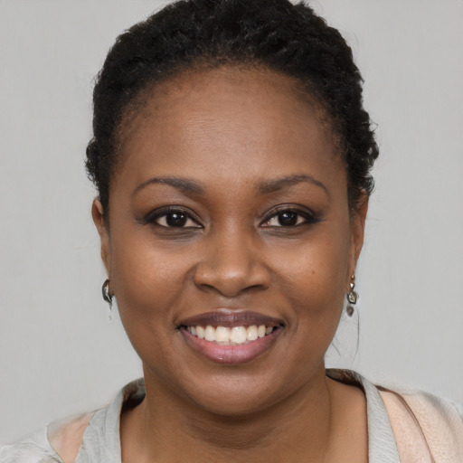 Joyful black young-adult female with short  brown hair and brown eyes