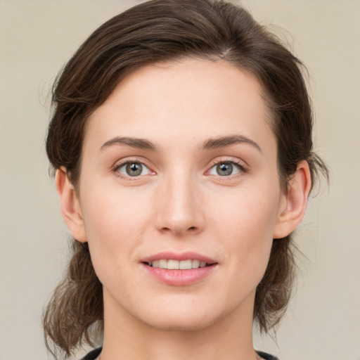 Joyful white young-adult female with medium  brown hair and green eyes