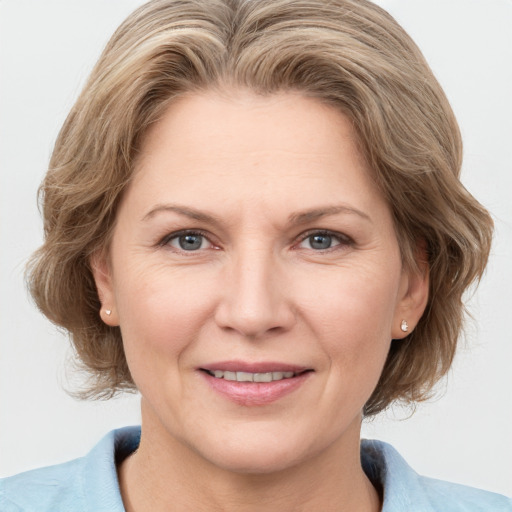 Joyful white adult female with medium  brown hair and blue eyes