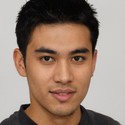 Joyful asian young-adult male with short  brown hair and brown eyes