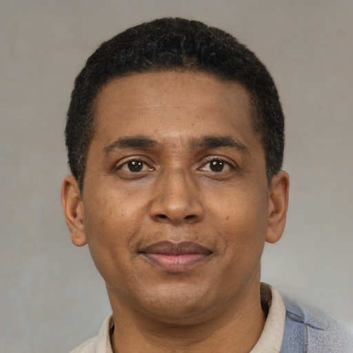 Joyful black adult male with short  brown hair and brown eyes