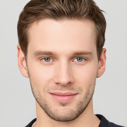 Joyful white young-adult male with short  brown hair and grey eyes