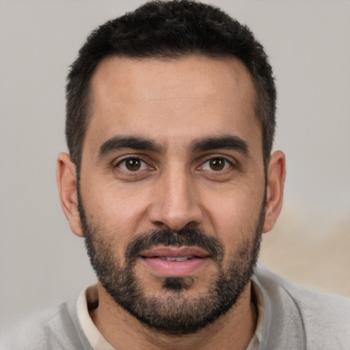 Joyful white young-adult male with short  black hair and brown eyes