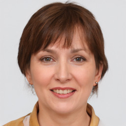 Joyful white adult female with medium  brown hair and grey eyes