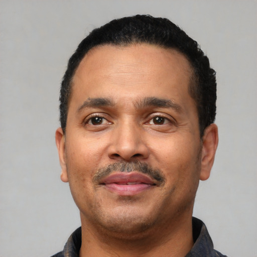 Joyful latino adult male with short  black hair and brown eyes