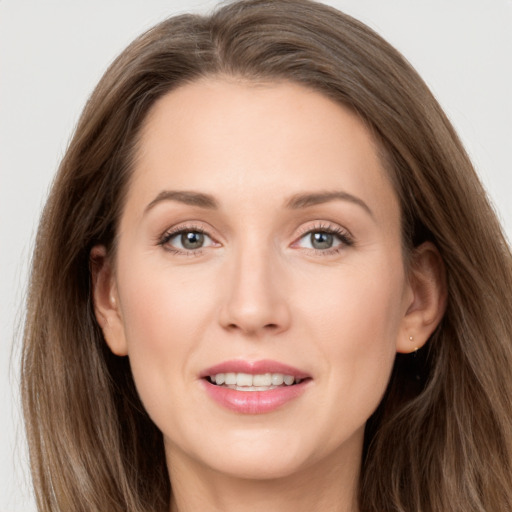 Joyful white young-adult female with long  brown hair and grey eyes