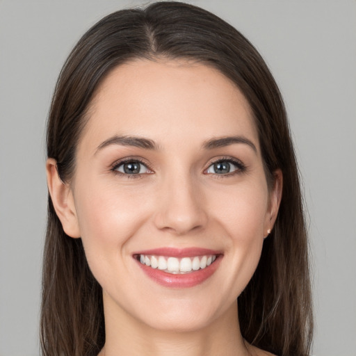 Joyful white young-adult female with long  brown hair and brown eyes