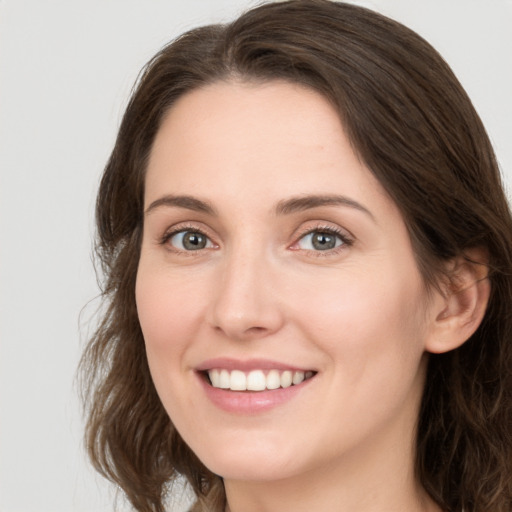 Joyful white young-adult female with long  brown hair and green eyes