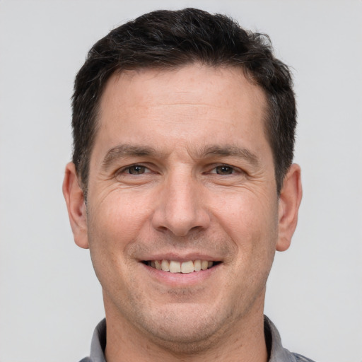 Joyful white adult male with short  brown hair and brown eyes