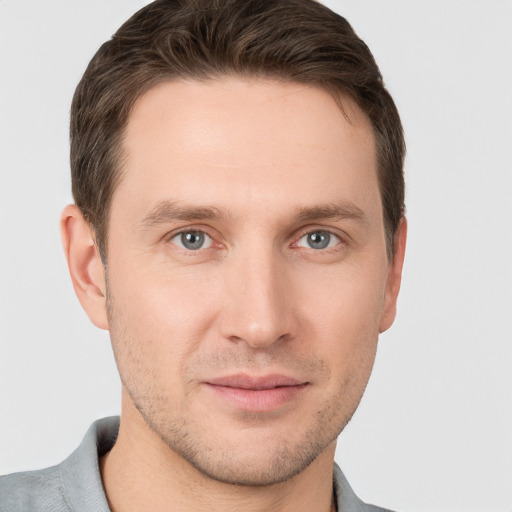 Joyful white young-adult male with short  brown hair and grey eyes