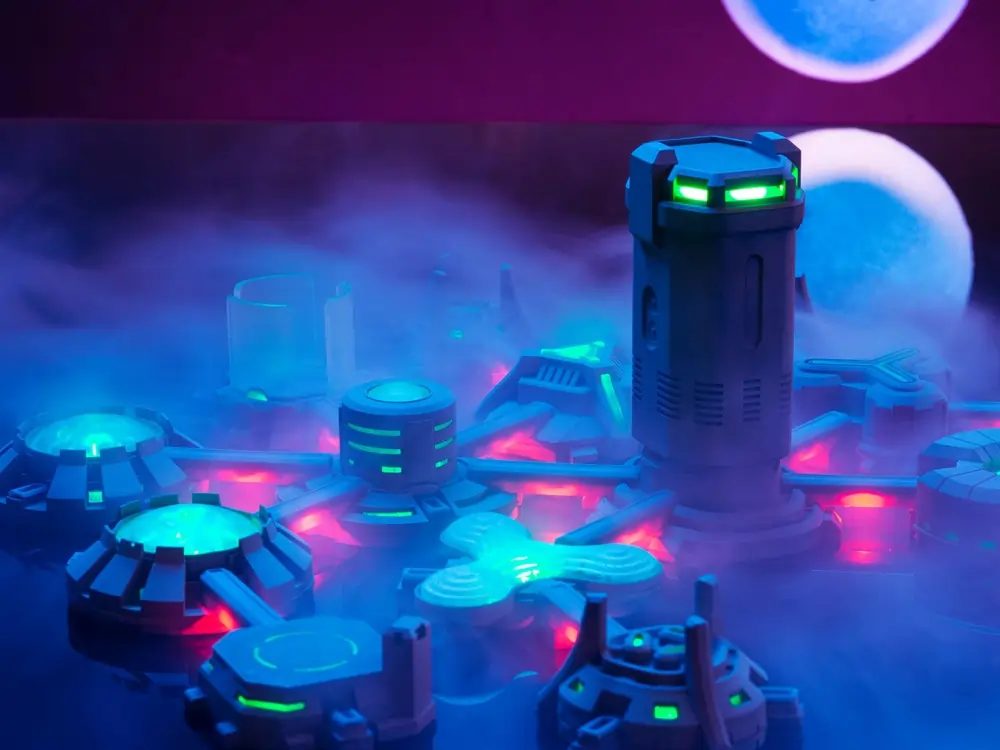 Beyond Humanity: Colonies sci-fi board game with glowing robotic buildings and electronic components