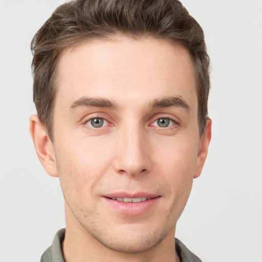 Joyful white young-adult male with short  brown hair and grey eyes