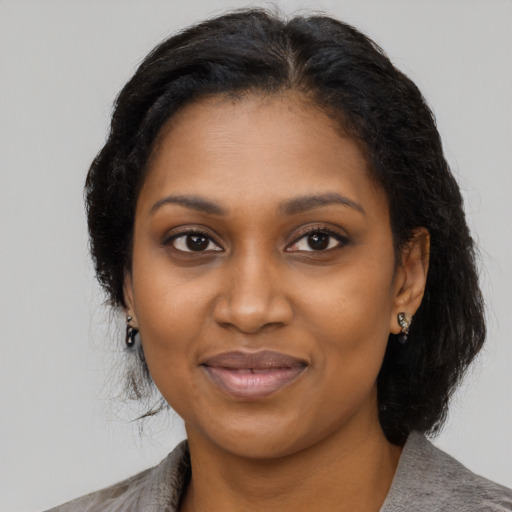 Joyful black young-adult female with medium  black hair and brown eyes