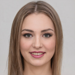 Joyful white young-adult female with long  brown hair and green eyes