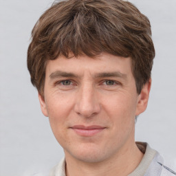 Joyful white adult male with short  brown hair and grey eyes