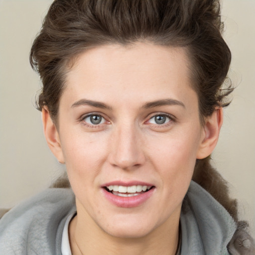 Joyful white young-adult female with short  brown hair and grey eyes