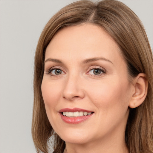 Joyful white adult female with long  brown hair and brown eyes