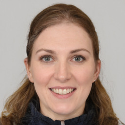 Joyful white young-adult female with long  brown hair and grey eyes