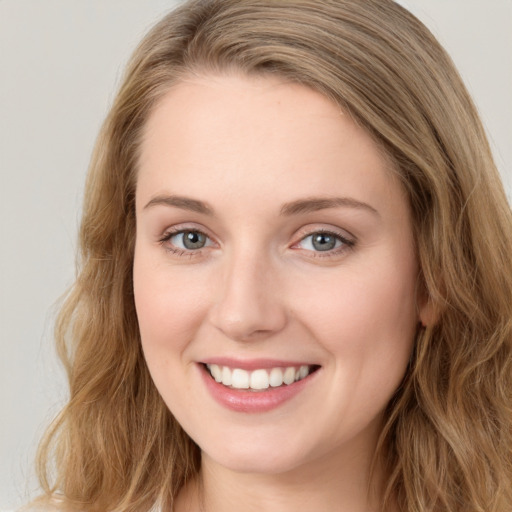 Joyful white young-adult female with long  brown hair and blue eyes