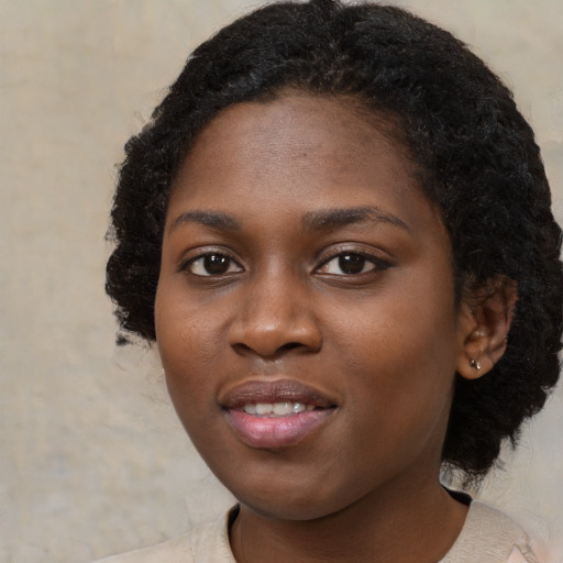 Joyful black young-adult female with medium  black hair and brown eyes