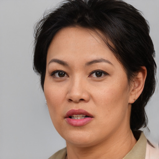 Joyful asian adult female with short  brown hair and brown eyes