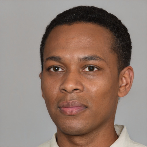 Joyful black young-adult male with short  black hair and brown eyes