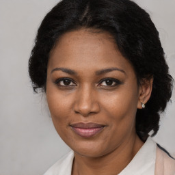 Joyful black adult female with medium  brown hair and brown eyes