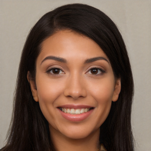 Joyful latino young-adult female with long  brown hair and brown eyes