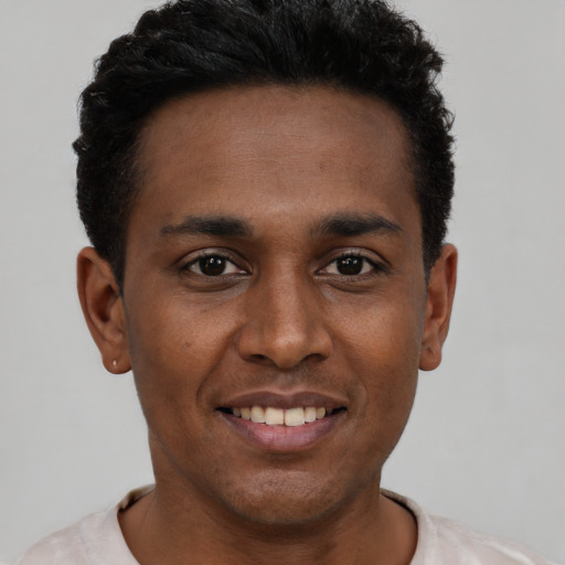 Joyful black young-adult male with short  black hair and brown eyes