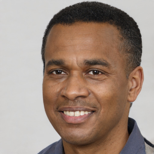 Joyful black adult male with short  black hair and brown eyes