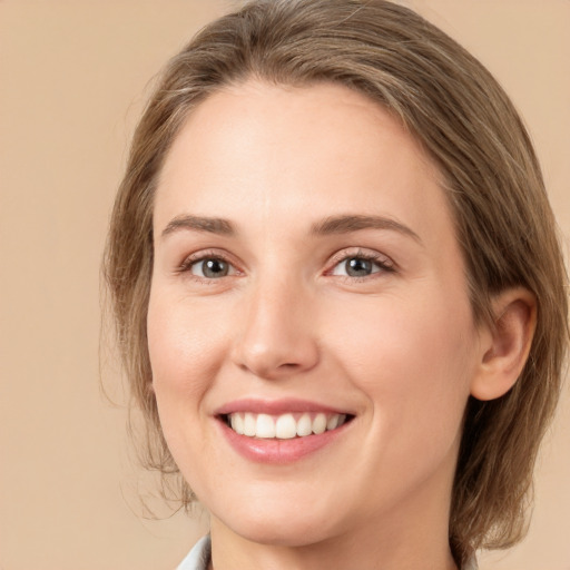 Joyful white young-adult female with medium  brown hair and green eyes