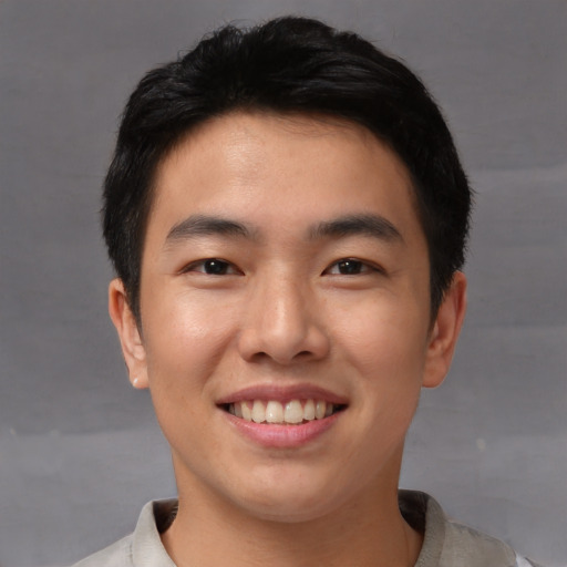 Joyful asian young-adult male with short  black hair and brown eyes