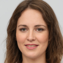 Joyful white young-adult female with long  brown hair and green eyes