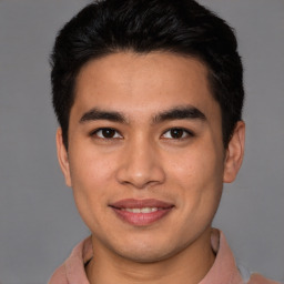 Joyful latino young-adult male with short  brown hair and brown eyes