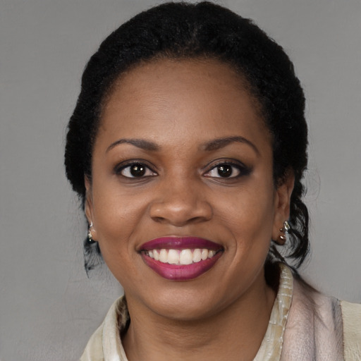 Joyful black young-adult female with long  black hair and brown eyes