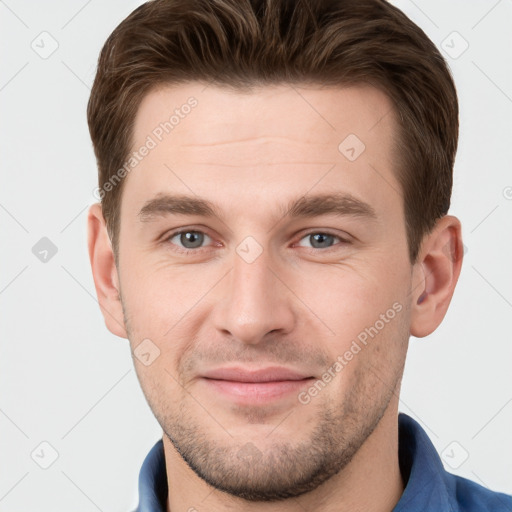 Joyful white young-adult male with short  brown hair and grey eyes