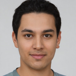 Joyful latino young-adult male with short  brown hair and brown eyes