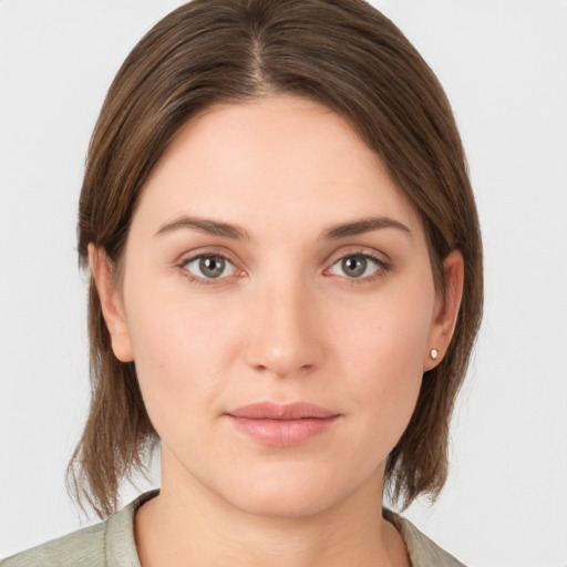 Joyful white young-adult female with medium  brown hair and grey eyes