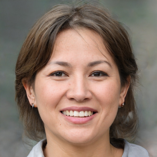 Joyful white adult female with medium  brown hair and brown eyes