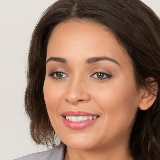 Joyful white young-adult female with long  brown hair and brown eyes