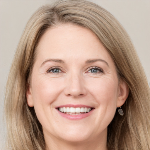 Joyful white adult female with long  brown hair and grey eyes